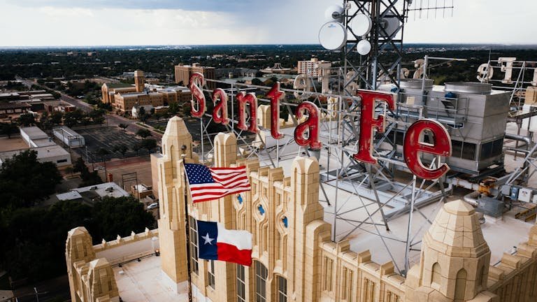 Aerial view of Santa Fe building rooftop with American and Texas flags in Amarillo, Texas.